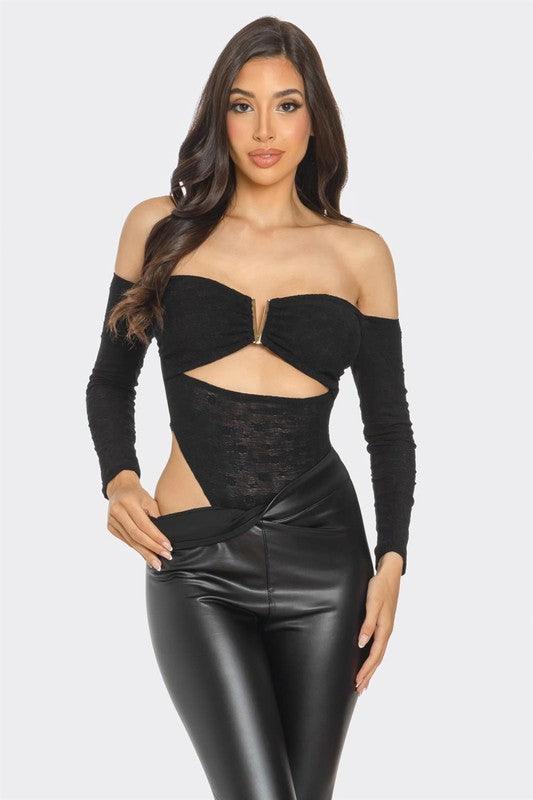 Front view of a model dressed in a black lace off-shoulder bodysuit with a center cut-out detail, paired with high-waisted black faux leather pants. The bodysuit features a gold accent clasp in the center, creating a bold, seductive look, perfect for a confident and fashion-forward appearance.